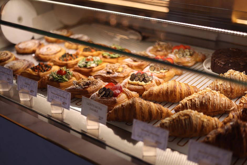 An inviting display of various pastries and croissants inside a bakery showcase.